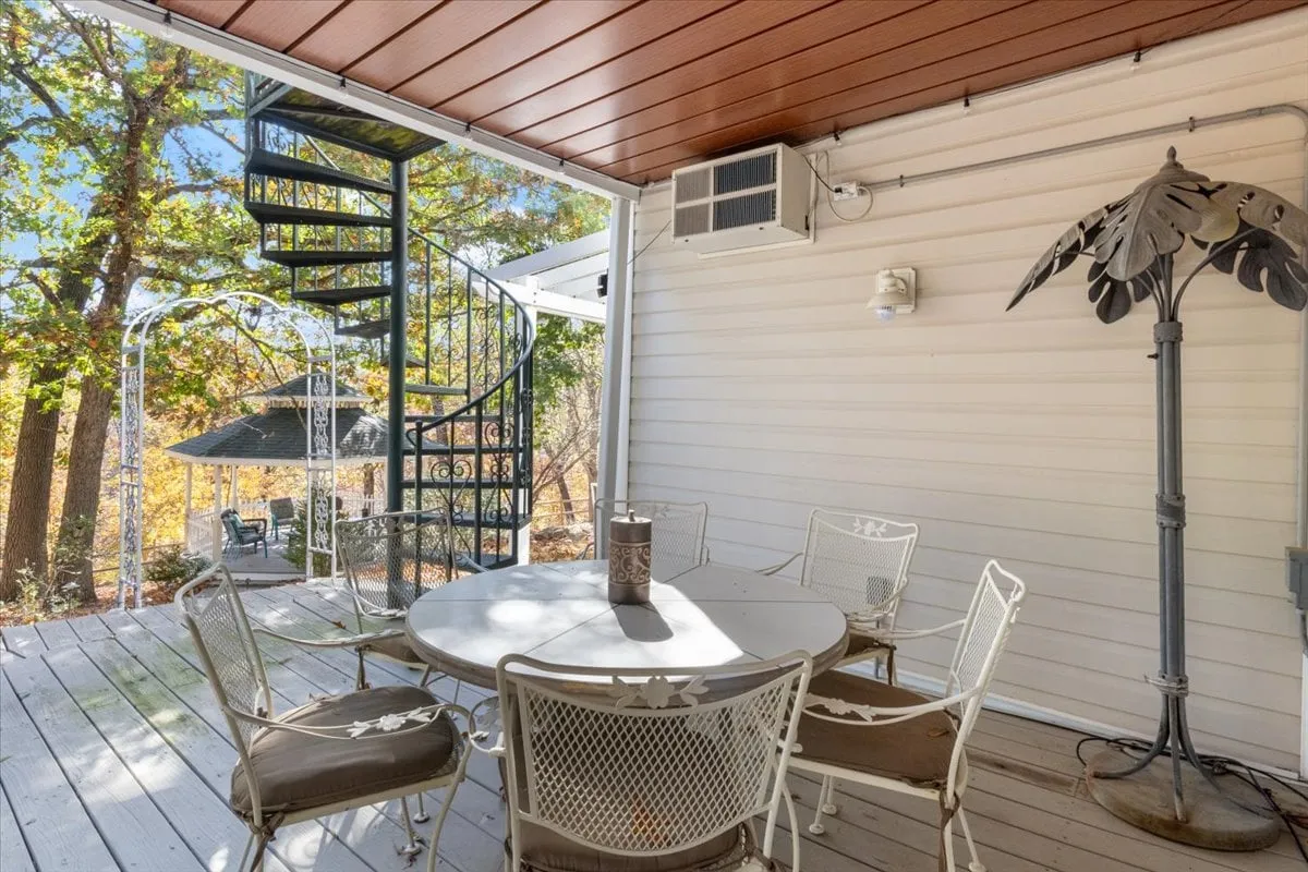 An exterior shot of a round outdoor dining table with a decorative lamp, next to a spiral staircase. The space is ideal for sunset dinners, stargazing, or enjoying local wine and brews in a relaxed and welcoming setting.