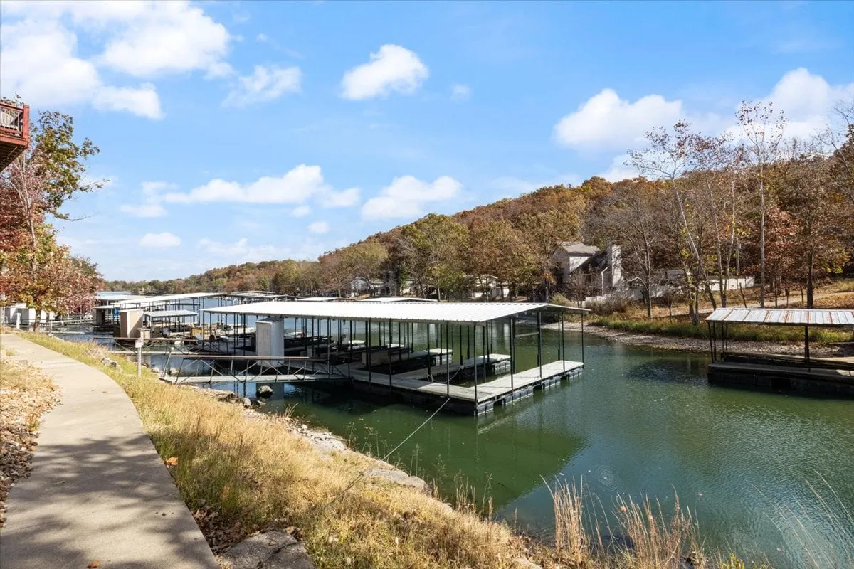 A scenic lakeside view of community boat docks surrounded by calm water and lush trees, evoking relaxation and adventure. The scene is peaceful, with opportunities for fishing, boating, or simply soaking in the views.