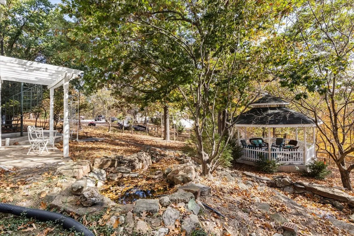 This image depicts a charming gazebo set amidst natural rock formations and an inviting outdoor seating area. The scene conveys a tranquil, social atmosphere, perfect for relaxing after a day of exploring local tasting rooms and eateries.