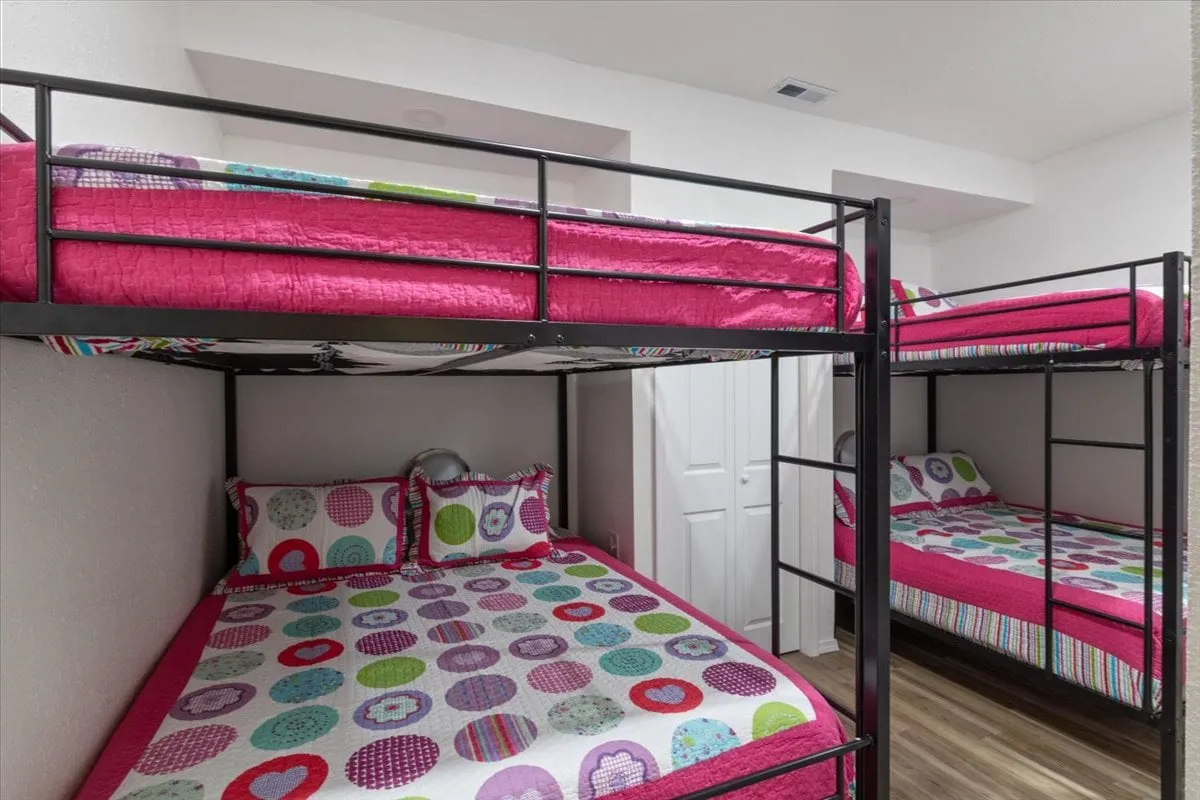 A playful and vibrant bunk room with colorful bunk beds, decorative pillows, and a lively atmosphere. The space is cozy and cheerful, clearly designed for children or extra guests to relax and enjoy their own private space.
