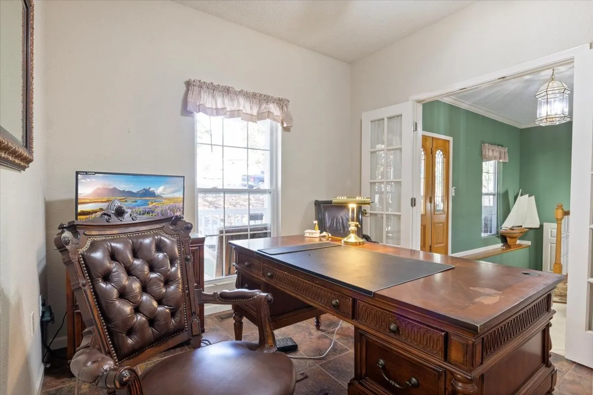 A stylish home office nook with a wooden desk, comfortable leather chair, computer monitor, and a window that lets in natural light. The space is ideal for productivity, planning, or accessing personalized recommendations.